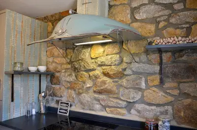 a stone wall with a hood over a table at Sea Haze Charlestown in St Austell