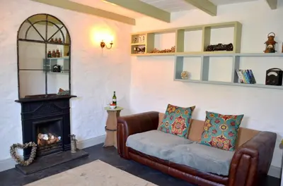 a living room with a couch and a fireplace at Sea Haze Charlestown in St Austell