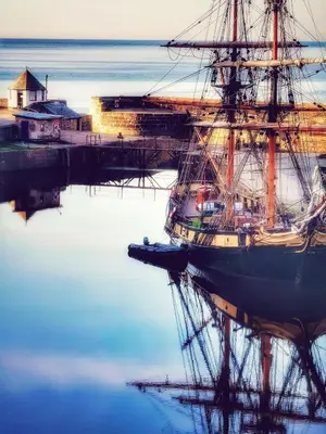 a tall ship docked at a dock in the water at Sea Haze Charlestown in St Austell