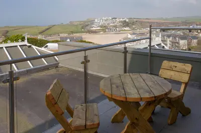 a wooden table and two chairs on a balcony at Sure Hotel Collection by Best Western Porth Veor Manor Hotel in Newquay