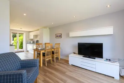 a living room with a couch and a tv at Bay Retreat Villas in Padstow