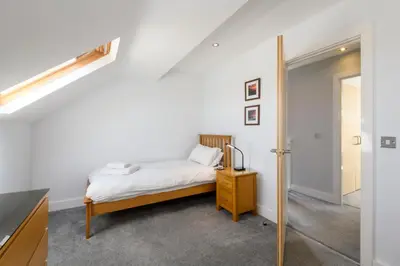 a small bedroom with a bed and a mirror at Bay Retreat Villas in Padstow