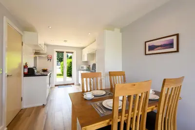 a kitchen and dining room with a table and chairs at Bay Retreat Villas in Padstow