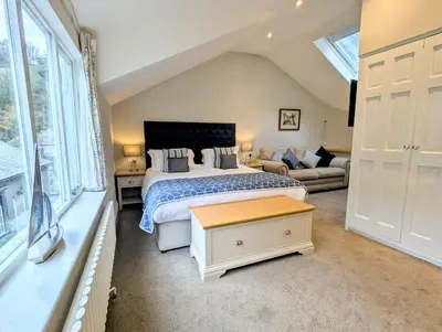 a bedroom with a king sized bed and a couch at The Claremont Hotel-Adult Only in Polperro