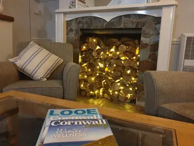 a living room with a fireplace with lights in it at The Claremont Hotel-Adult Only in Polperro