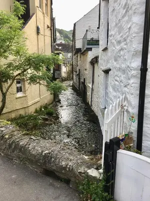 an alley between two buildings with a white fence at The Claremont Hotel-Adult Only in Polperro