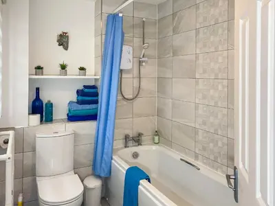 a bathroom with a tub and a toilet and a shower at Spinnakers in Falmouth