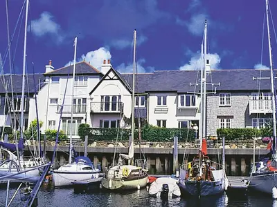 a group of boats docked in front of a large building at Spinnakers in Falmouth