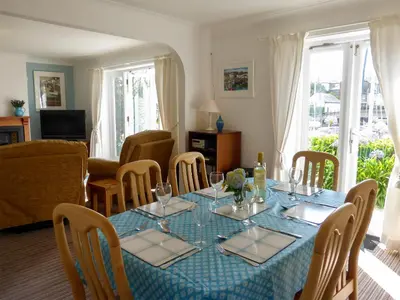 a dining room with a blue table and chairs at Spinnakers in Falmouth