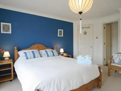 a bedroom with a large bed with a blue wall at Spinnakers in Falmouth