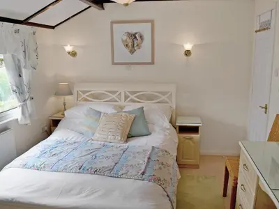 a bedroom with a large white bed in a room at Driftwood in St Merryn