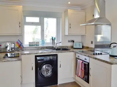 a kitchen with a washer and a sink at Puffins in Port Isaac