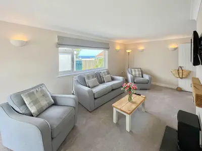 a living room with two couches and a table at Silvershell View in Port Isaac