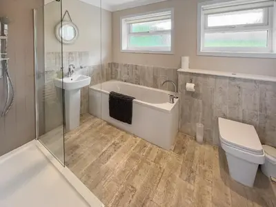 a bathroom with a tub and a toilet and a sink at Silvershell View in Port Isaac