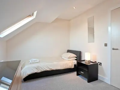 a small bedroom with a bed and a night stand at Bay Retreat Villas in St Merryn