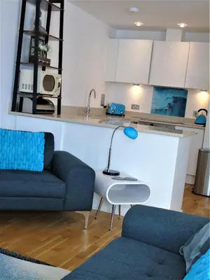 a living room with a couch and a table at Seaview, Luxury apartment, 2 min walk to Porth Beach in Newquay