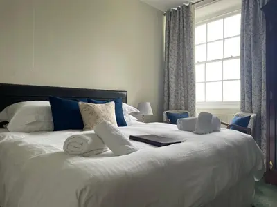 a bedroom with a large white bed with towels on it at Trevanger Farm Bed and Breakfast in Wadebridge