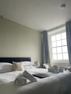 a bedroom with a large bed with towels on it at Trevanger Farm Bed and Breakfast in Wadebridge