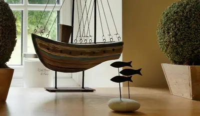 a wooden boat on a stand in a room with plants at Caroe Farm House in Otterham