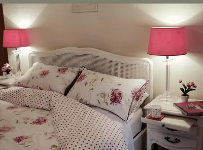 a bedroom with a bed with pink lamps and pink pillows at Caroe Farm House in Otterham