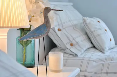 a statue of a bird on a table next to a couch at Caroe Farm House in Otterham