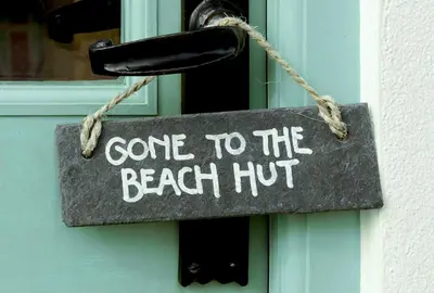 a sign that says come to the beach hut on a door at Caroe Farm House in Otterham