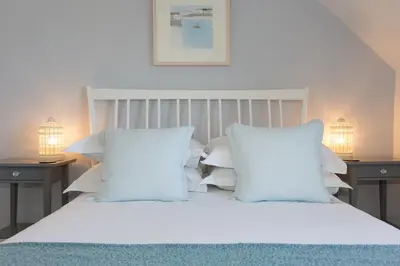 a white bed with white pillows and two lamps at 3 Porthminster B&B in St Ives