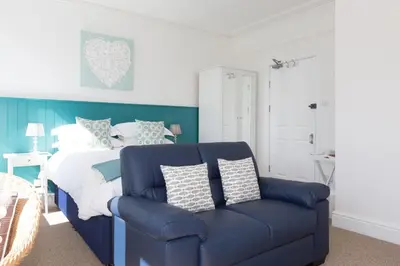 a bedroom with a bed and a blue couch at 3 Porthminster B&B in St Ives