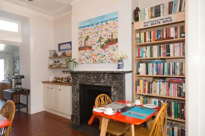 a dining room with a table and a fireplace at 3 Porthminster B&B in St Ives
