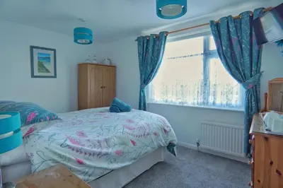 a bedroom with a bed and a window at The Old Coach House in Boscastle