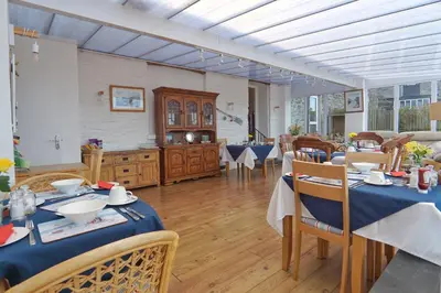 a dining room with a table with blue table cloth at The Old Coach House in Boscastle