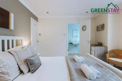 a white bedroom with a bed and a bathroom at 