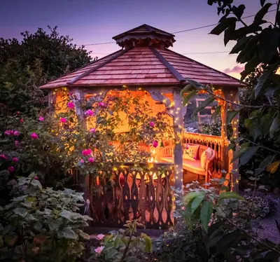 a gazebo decorated with lights in a garden at Rockleigh Place in St Austell