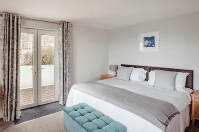 a bedroom with a large bed and a window at The Bay Hotel in Coverack