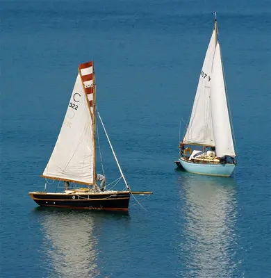 two sailboats floating in the water next to each other at The Bay Hotel in Coverack