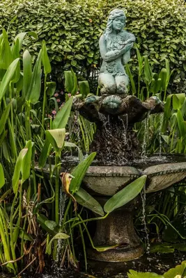 a statue of a woman sitting on top of a fountain at The Bay Hotel in Coverack