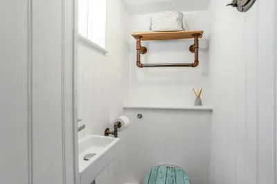 a white bathroom with a sink and a toilet at The Bunker House in Newquay