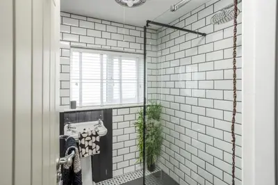 a bathroom with white subway tiles and a window at The Bunker House in Newquay