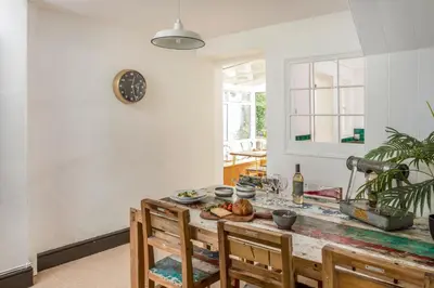 a kitchen with a table with chairs and a clock on the wall at The Bunker House in Newquay