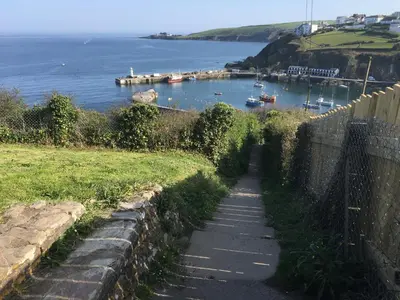 a path next to a body of water with boats in it at Linton Luxury Holiday Home in Mevagissey