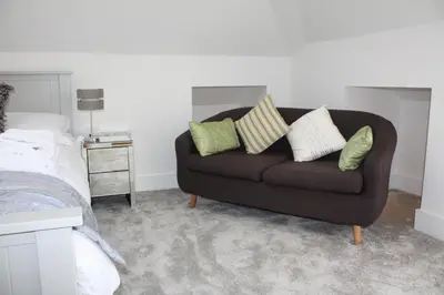 a couch with four pillows in a bedroom at Linton Luxury Holiday Home in Mevagissey