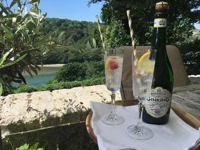 a bottle of champagne and two glasses on a table at Woodlands in Looe