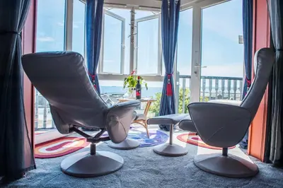 three chairs sitting in a room with windows at Poltair Guest House in Falmouth