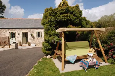 a gazebo with a bench in a yard at The Snuggery in Truro
