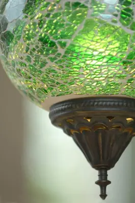 a green glass chandelier hanging from a ceiling at The Snuggery in Truro