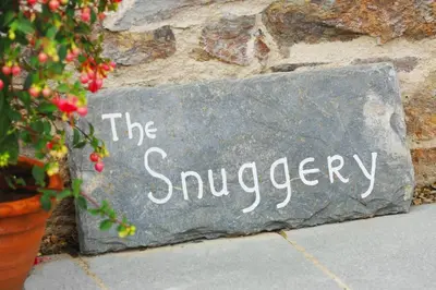 a sign that says the surveyery on a rock at The Snuggery in Truro