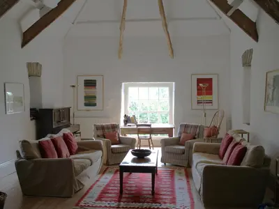 a living room with couches and a table and a window at Harry in Bodmin