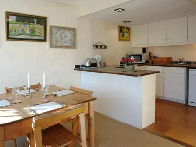 a kitchen with a table and a counter top at Dick Cottage in Bodmin