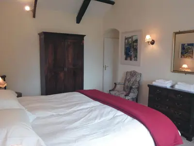 a bedroom with a bed and a dresser with a red blanket at Higher Tumrose in Blisland