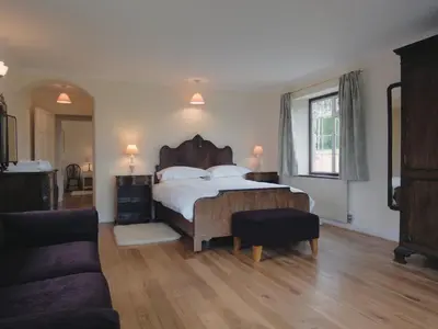 a bedroom with a large bed and a couch at Higher Tumrose in Blisland